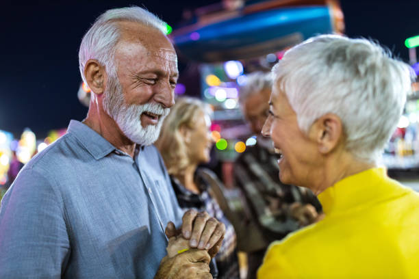 istock Loving senior couple talking at amusement park by night. 1185367917