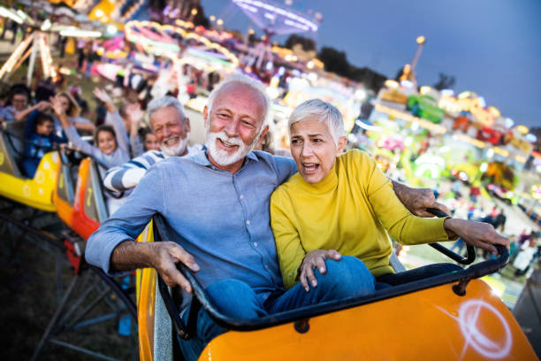 istock Happy senior couple having fun while riding on rollercoaster at amusement park. 1185368031
