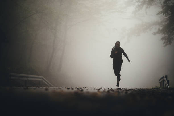 istock Determined athletic woman running through misty nature. 1185368793