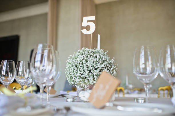 istock Table set at the wedding Banquet in the restaurant, classic style with white tablecloths and napkins, vases with flowers. 1185369210
