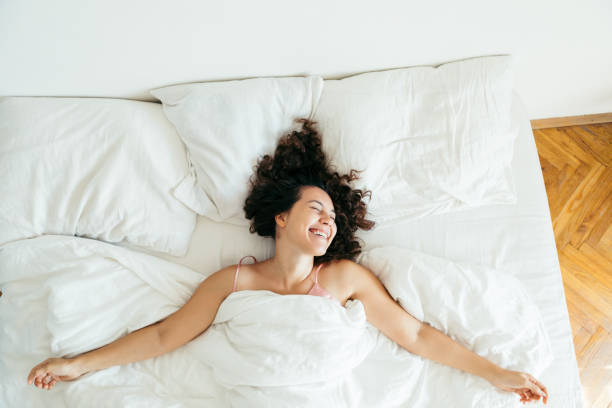 istock young pretty woman in bed with white sheets bright light copy space 1185370382