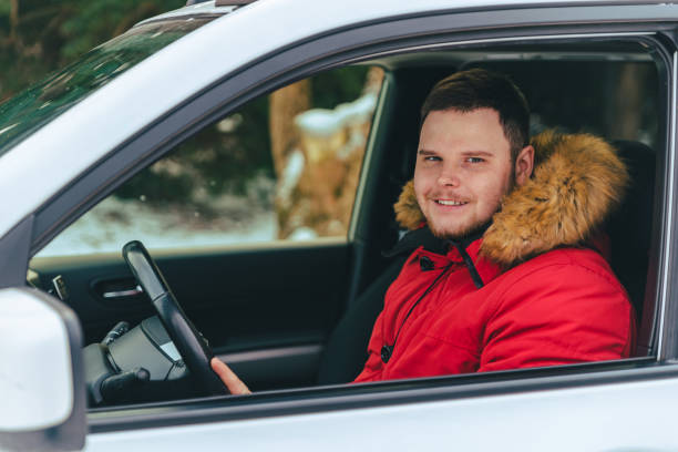 istock man in car at winter time looking at camera road trip 1185370556