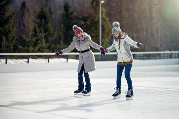 istock Mother and daughter ice-skating on outdoors rink 1185370867