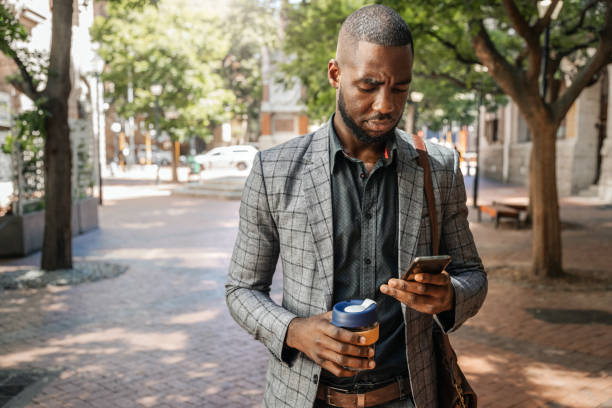 istock African Businessman Text Messaging And Holding A Cup Of Coffee 1185371939