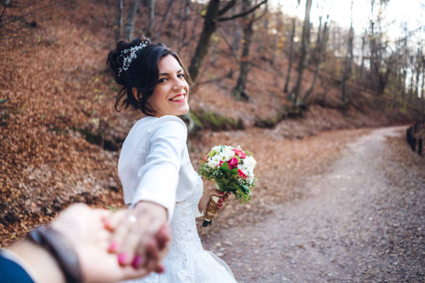 Young caucasian beautiful newlyweds making selfie in nature. POV. Follow me concept.