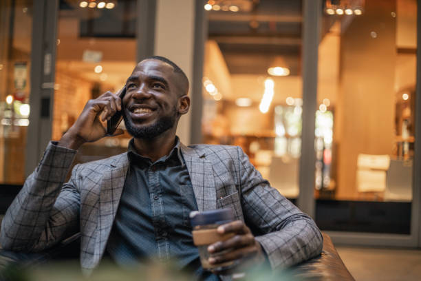istock Young Man Talking On The Phone And Drinking Coffee 1185372813