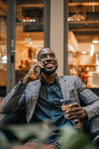 istock Young Man Talking On The Phone And Drinking Coffee 1185372856