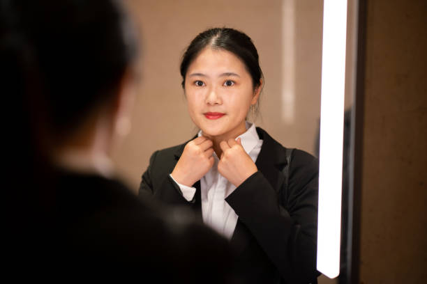 istock Young Asian businesswoman getting dressed 1185372869