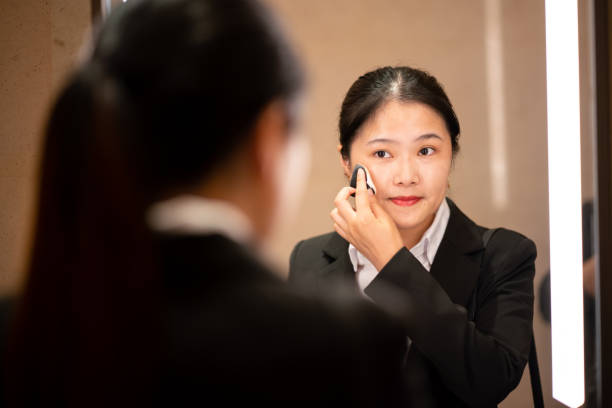 istock Young Asian woman applying face powder 1185372875