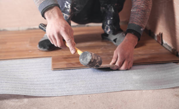 istock Worker installing wood laminate on the floor. 1185372906