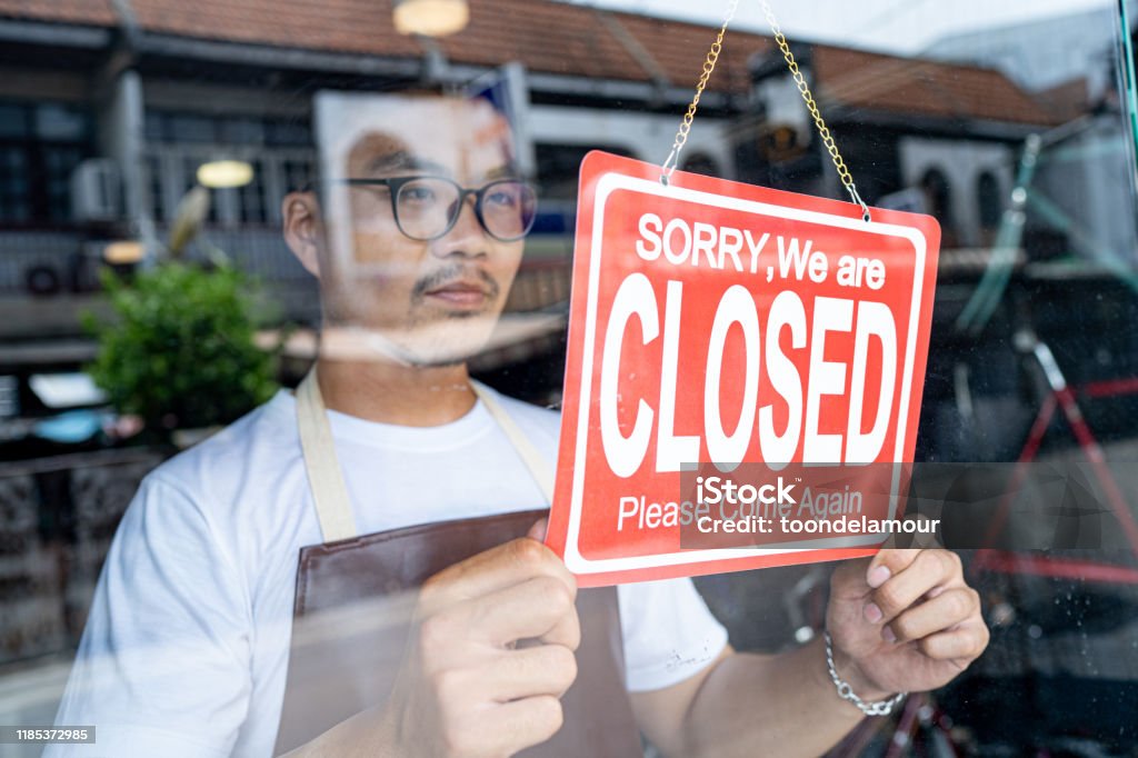 the owner of a small business shop came to closed the shop. Closing Stock Photo