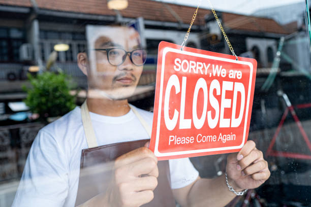 właściciel małego sklepu firmowego przyszedł, aby zamknąć sklep. - closed zdjęcia i obrazy z banku zdjęć