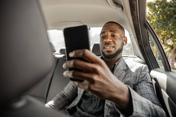istock African Businessman Riding In A Car On Back Seat Und Text Messaging 1185373084