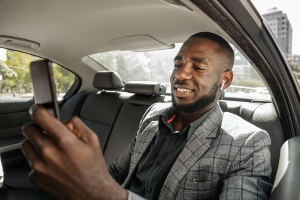 istock African Businessman Riding In A Car On Back Seat Und Text Messaging 1185373111