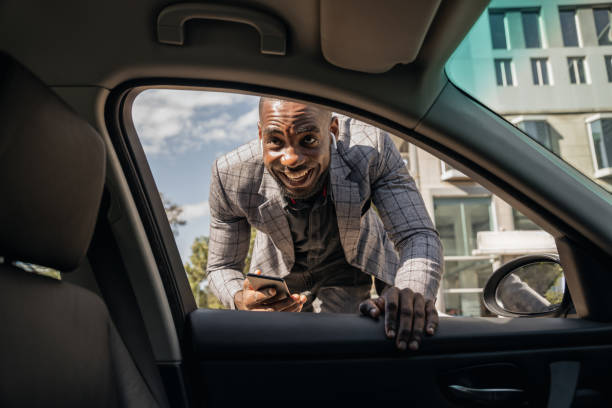 istock Young African Businessman Talking To Car Pooling Driver 1185373148