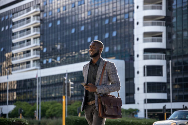 istock Businessman Crossing The Street And Using Smart Phone 1185373368