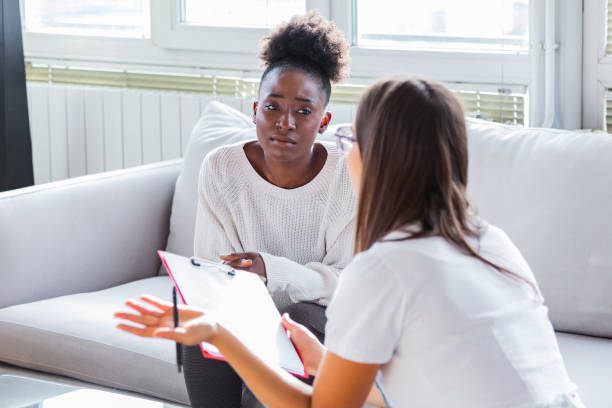 paziente che riceve cattive notizie, è disperata e piange, il dottore sostiene e conforta la sua paziente con simpatia. non preoccuparti, questo test medico non è così male - nurse doctor healthcare and medicine african descent foto e immagini stock