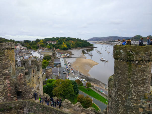 Tower and walls of Conwy Castle, an ancient 13th Century stone built fortification in North Wales, with a landscape and River Conwy at the background Tower and walls of Conwy Castle, an ancient 13th Century stone built fortification in North Wales, with a landscape and River Conwy at the background conwy castle stock pictures, royalty-free photos & images