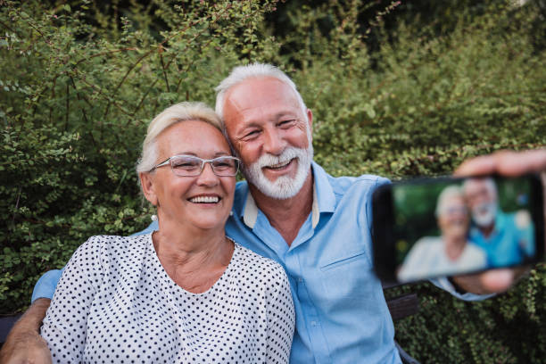 istock Smiling old couple hugging and taking selfie 1185380177
