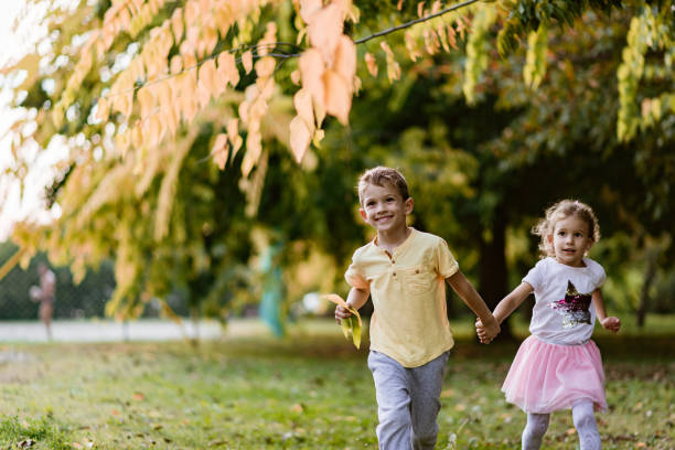 istock Beautiful kids running in an autumn park 1185382793