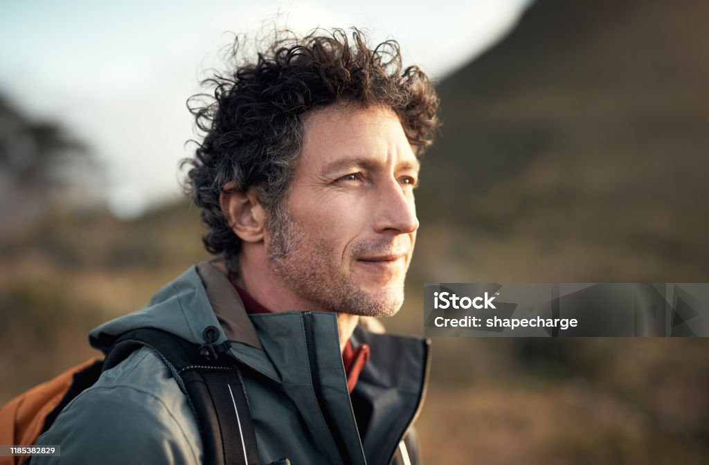 Hiking and determination go hand in hand Shot of a mature man going for a hike up a mountain Men Stock Photo