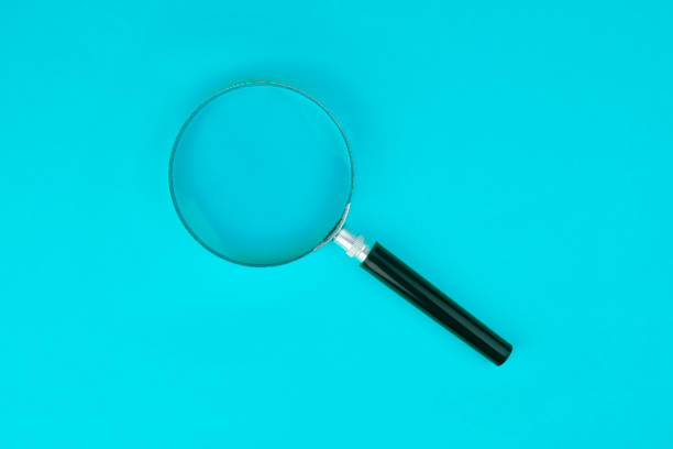 istock Magnifying glass stands on Blue Background 1185382905