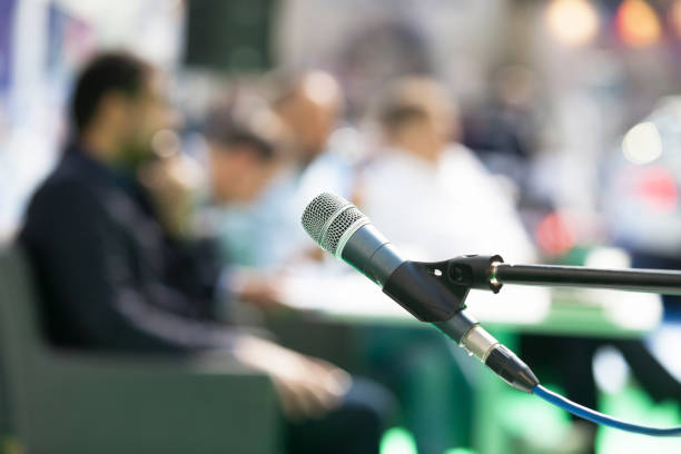 istock Microphone in focus against blurred people at roundtable event 1185384099