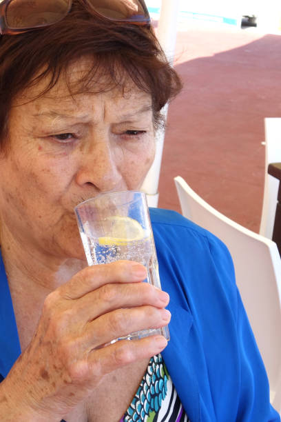 istock Old woman drinking water 1185386365
