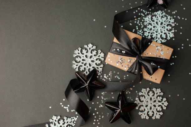 istock Christmas minimalistic and simple composition in mat black and silver color. Christmas gift, toys decorations on black background. Flat lay, top view with copy space, sale, discount 1185387158