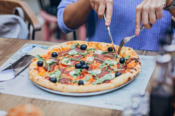 istock Lady eating pizza outdoors in pizzeria 1185387170
