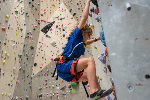istock Young boy is climbing an indoor climbing wall 1185388345