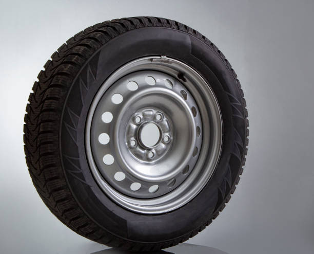 istock Car wheel and winter studded tire on white 1185389599