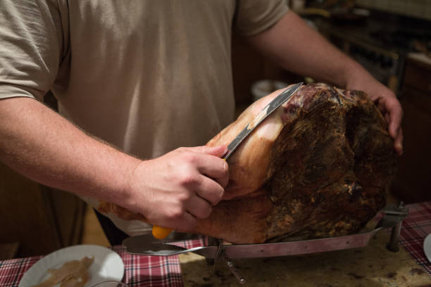 Home cutting of home made prosciutto: a man with the knife stock photo