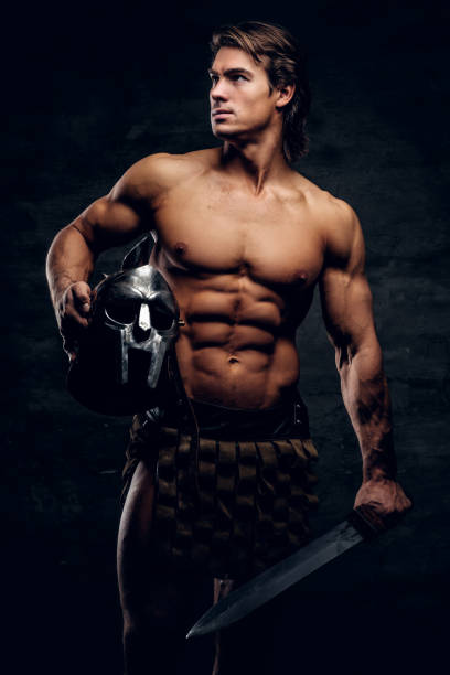 istock Manly athlete with sword and helmet in his hands 1185390972