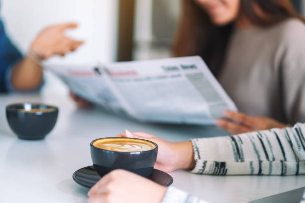istock people talking, reading newspaper and drinking coffee  together in the morning 1185391127
