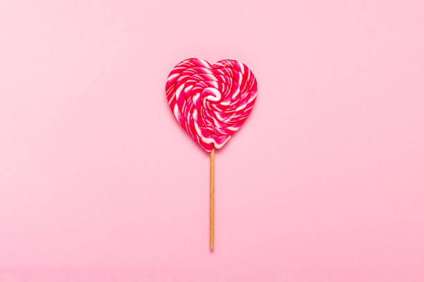 istock Lollipop on a gently pink background. Heart shape. Flat lay, top 1185392642