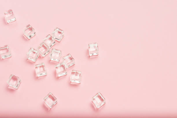 istock Ice cubes scattered on a light pink background. Flat lay, top vi 1185392681