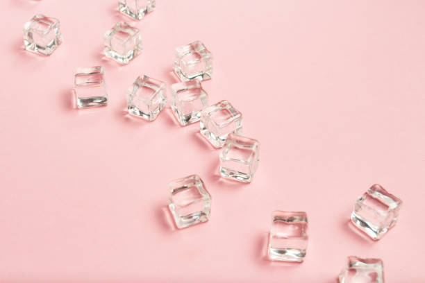 istock Ice cubes scattered on a light pink background. Flat lay, top vi 1185392702