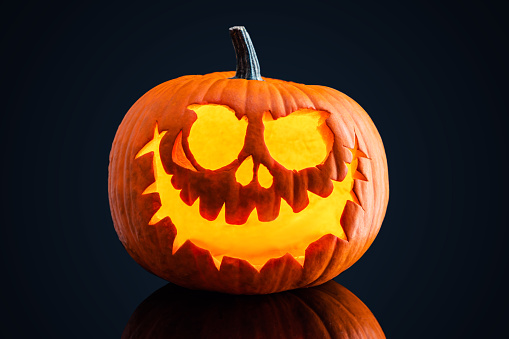 Halloween pumpkin scary face isolated on dark background.