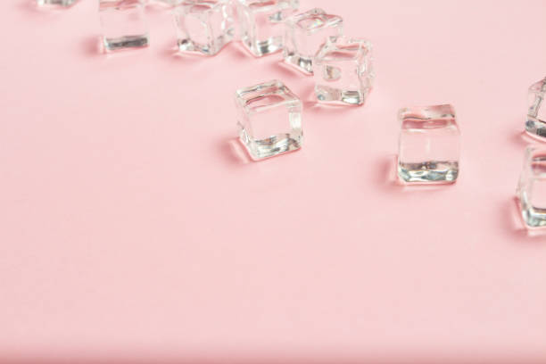 istock Ice cubes scattered on a light pink background. Flat lay, top vi 1185394371