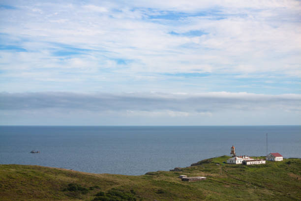 istock Lighthouse Povorotny against blue sky with white clouds 1185394610