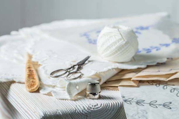 Thread, scissors and homemade white embroidered napkins