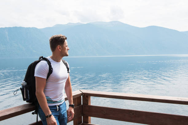 Man portrait on Teletskoye lake in Altai mountains, Siberia, Russia. Beauty summer day.