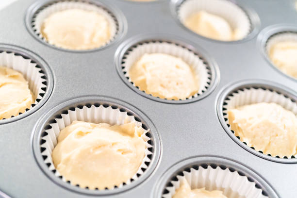 istock Scooping cupcake batter to bake vanilla cupcakes. 1185399223