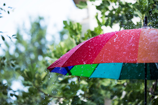 Summer rain on colorful umbrella