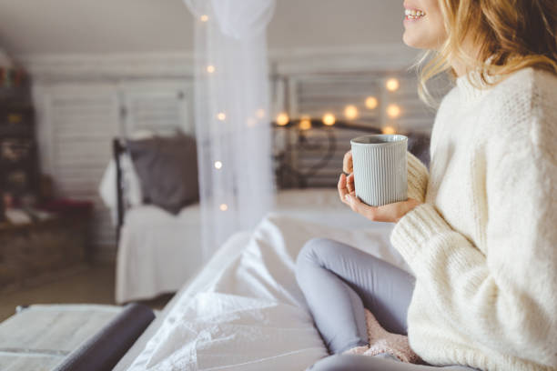 Beautiful young woman drinking coffee at home stock photo