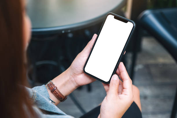 istock a woman holding a black mobile phone with blank white desktop screen 1185404667