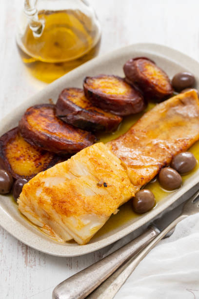 istock fried cod fish with olives and sweet potato on dish 1185404721