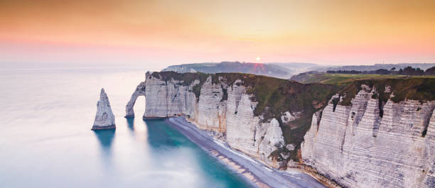 coastal landscape along the Falaise d'Aval the famous white cliffs of Etretat village, with the Porte d'Aval natural arch and the rock known as the Needle of Etretat stock photo