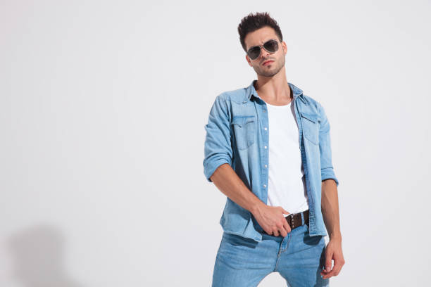 istock Tough fashion man fixing his belt and looking forward 1185407290